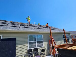 Solar panel and roofing installation crew working on a residential roof in St. Charles, MO